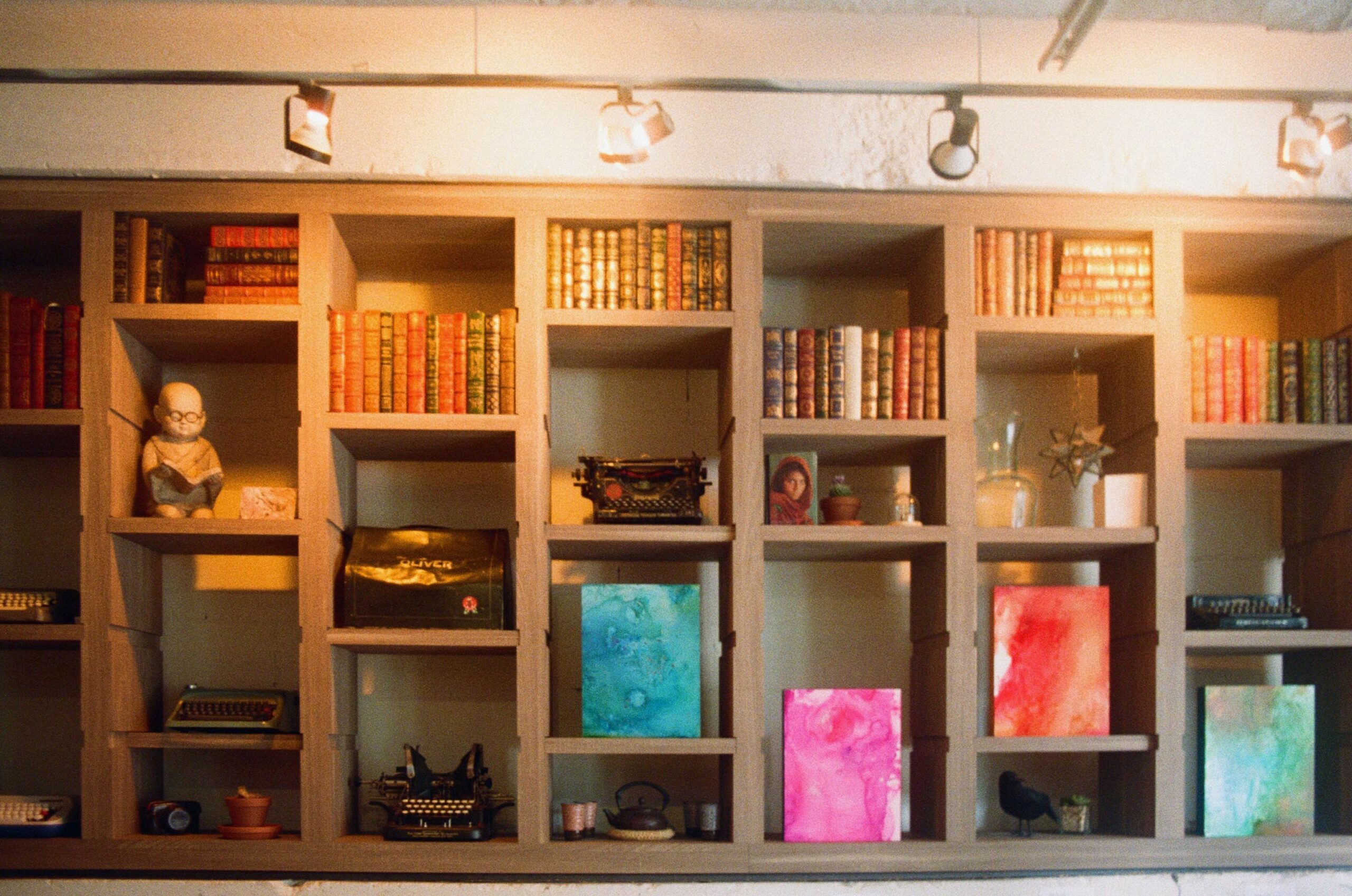 bookcase with books and typewriters